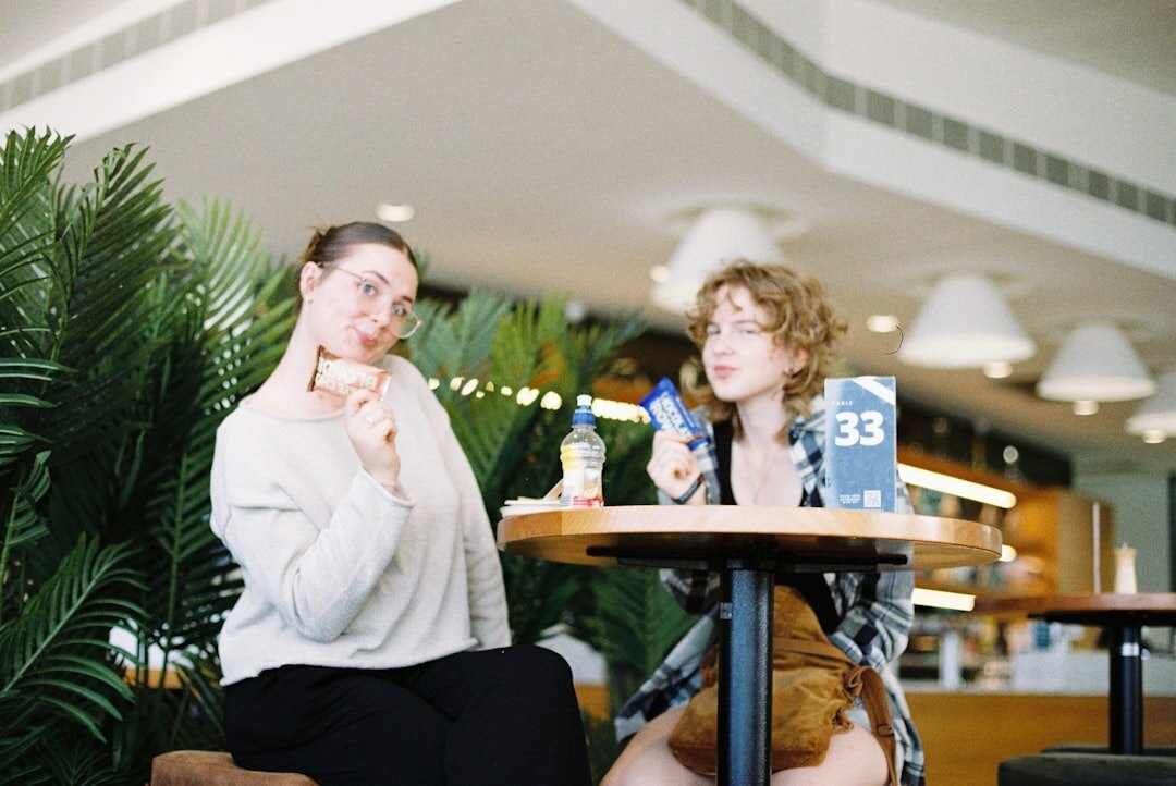 Two Uruguayan women discussing a book together at a wooden cafe table