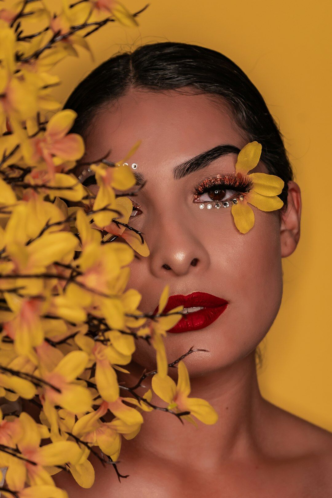 Studio portrait of a Uruguayan woman with short dark hair against a mustard yellow background